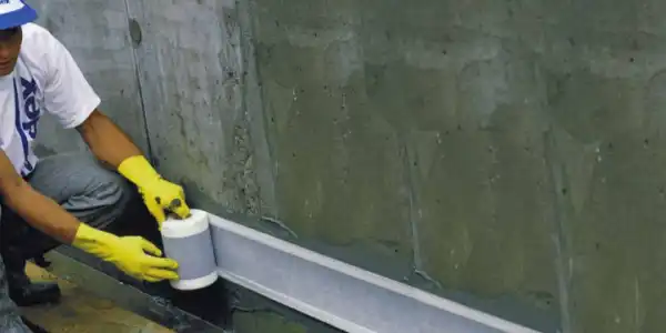 Man applying Vandex tape onto wall