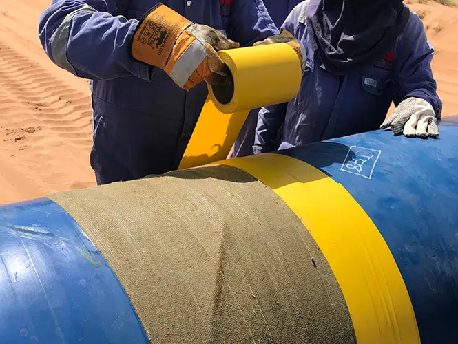 Men applying Denso tape